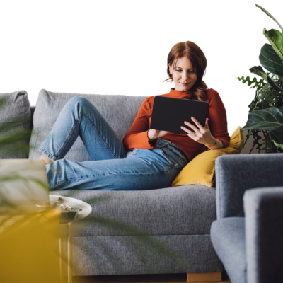 Woman sat on sofa browsing on a Tablet